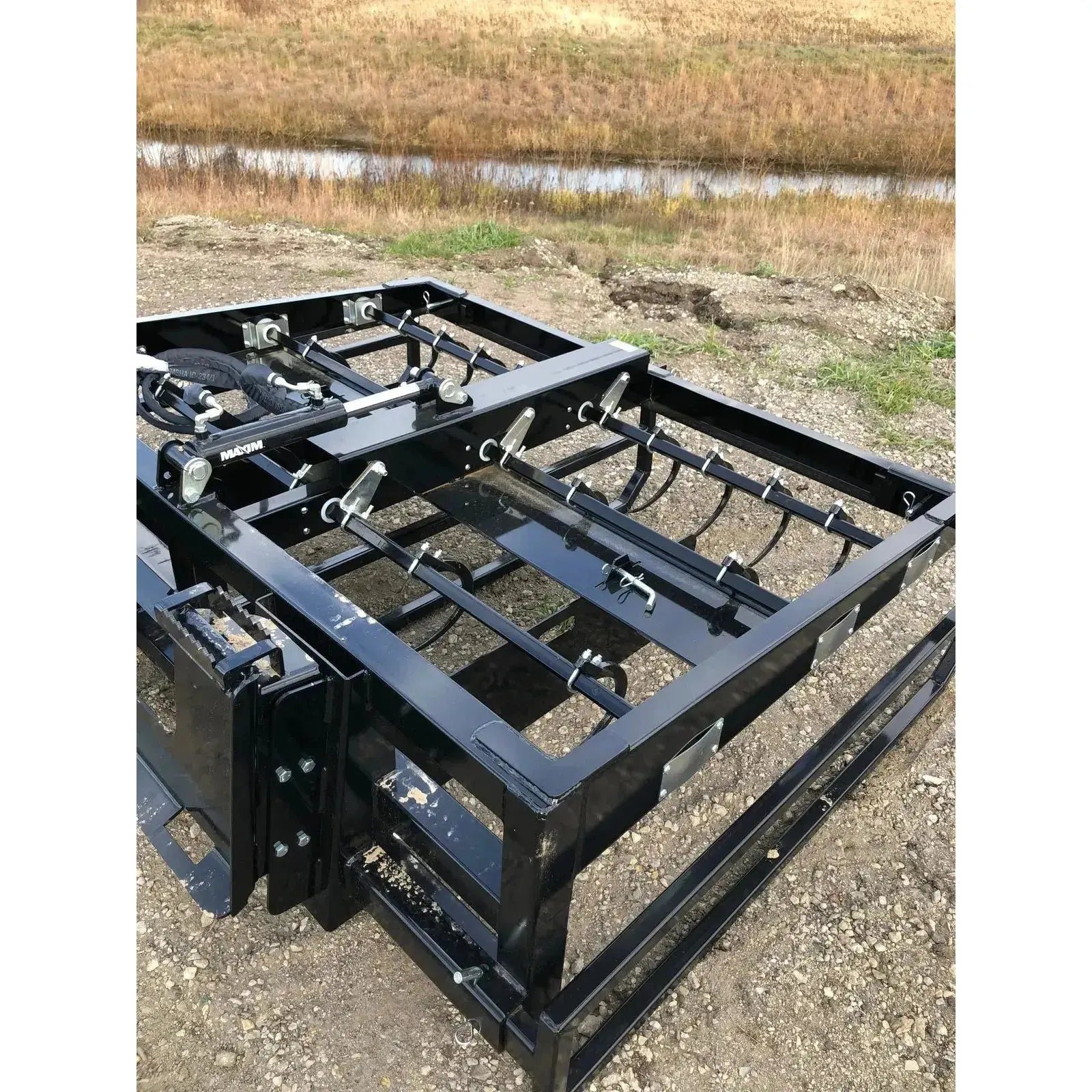 Close-up view of the robust design of Top Dog Attachments' 6-Pack Bale Accumulator Grapple in action. Top Dog Attachments