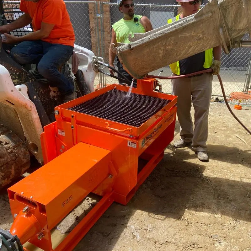 Close-up of the powerful and compact EZG Manufacturing Skid Steer Concrete Pump in operation.